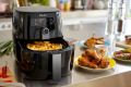 An air fryer with chips and chicken